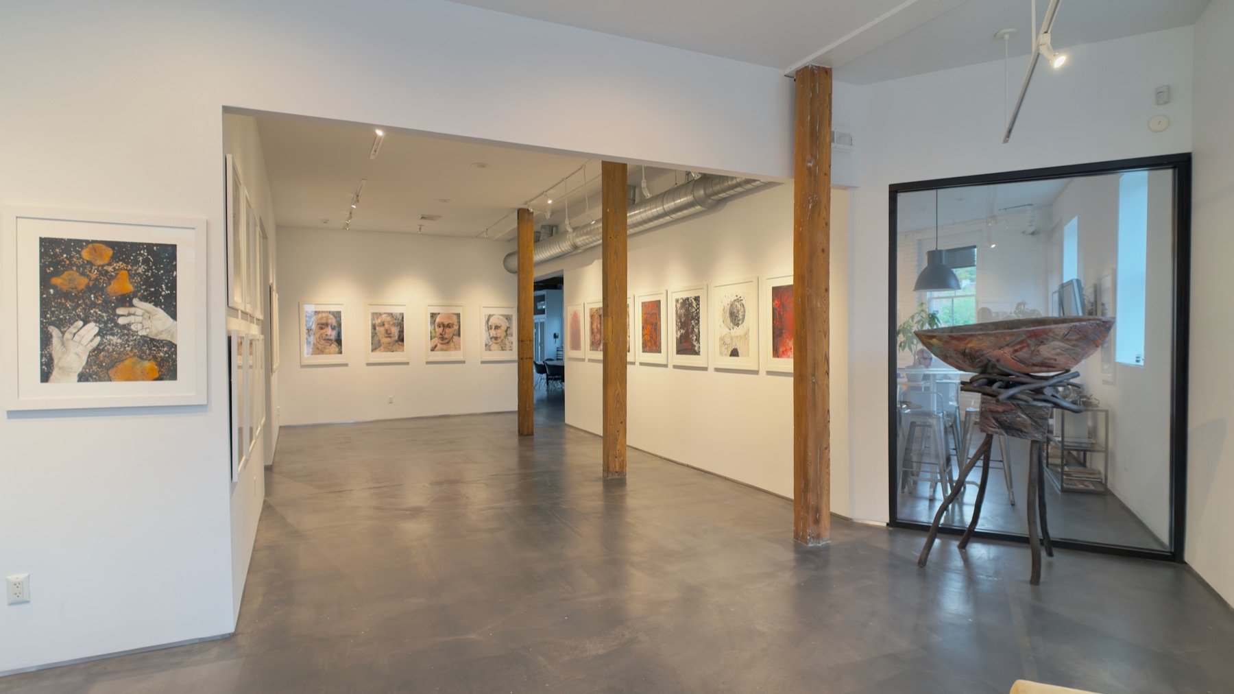 White-cube gallery room with framed works and track lighting