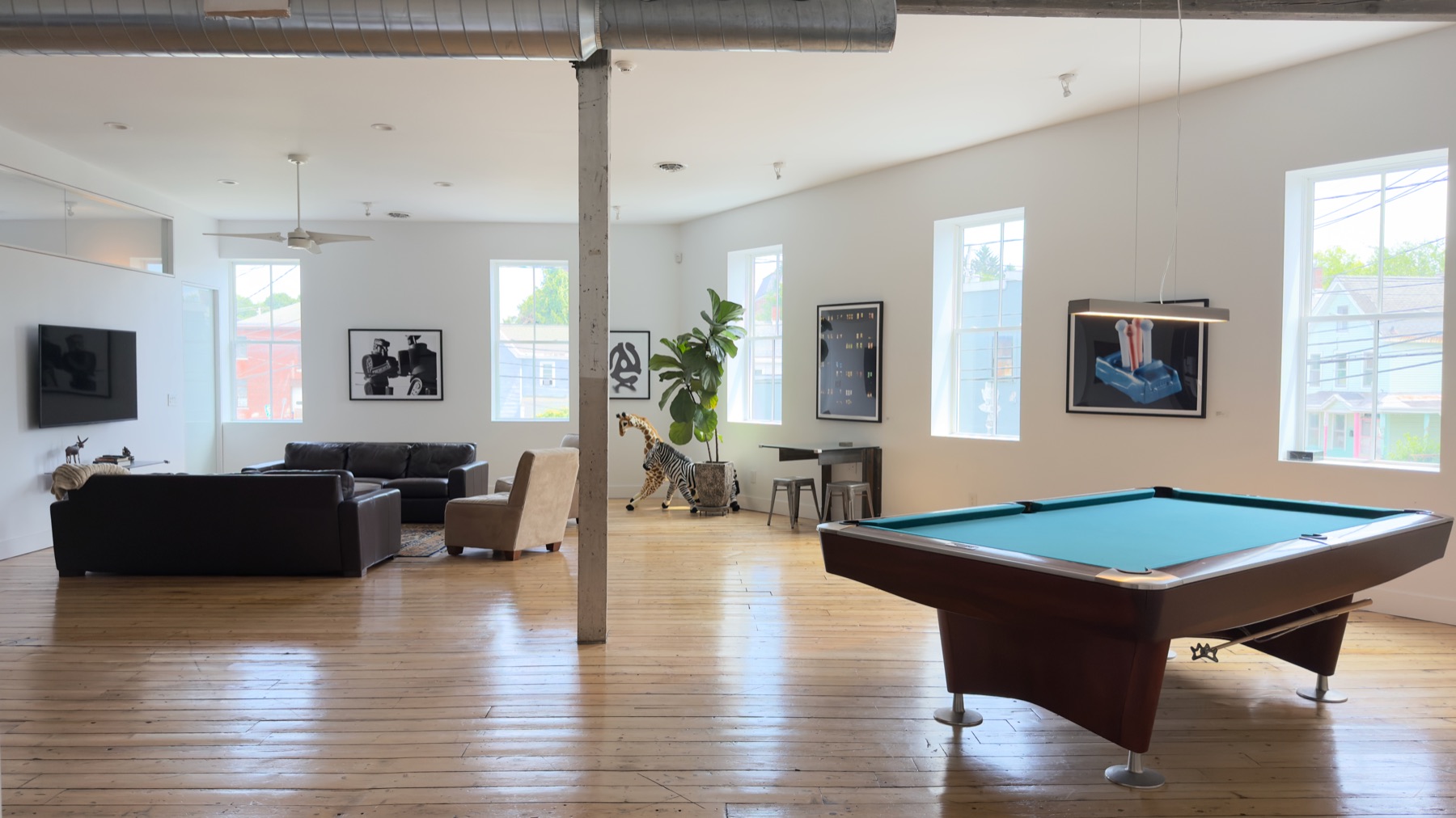 Loft lounge with pool table, leather sofas and original plank floors